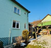 A family house in Horná Ves with a yard and a gazebo, surrounded by greenery and a blue facade.