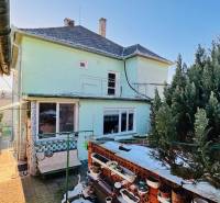 A family house in Horná Ves with a garden and a terrace, surrounded by greenery and decorative flower pots.