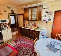 A kitchen in a family house with carpet and wooden cabinets, feels cozy.