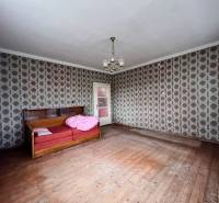 A room in a family house with retro wallpaper and a wooden decor floor.