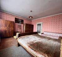 A bedroom in a family house with a wooden decor floor and upholstered furniture.