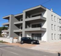 A recreational apartment in Vodice with balconies and a car on the driveway.