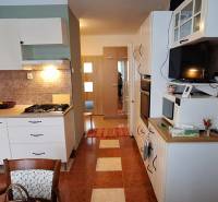 A kitchen in a 3-room apartment with white cabinets and a gas stove.
