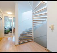 Interior of a family house, spiral staircase, wooden decor flooring, glass doors.