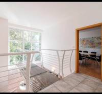 Hallway with windows and a table with chairs in a family house.