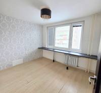 A room with a table and a wooden floor decor in a 3-room apartment.