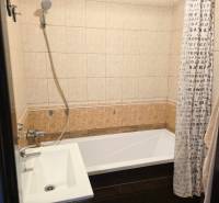 Bathroom in a 3-room apartment with a bathtub, sink, shower, and curtain with text.