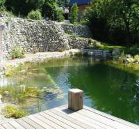 The garden of a family house in Hainburg an der Donau with a natural pond and a terrace.
