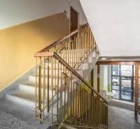 Staircase of a residential building with a window facing the street, entrance to a 3-room apartment.