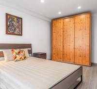 Bedroom in a 3-room apartment with a bed, wooden wardrobe, and floor with wooden decor.