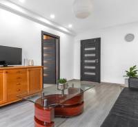 Living room in a 3-room apartment with a sofa, television, and a wooden decor floor.