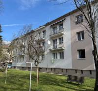 Apartment building on Ľ. Štúr Street in the city of Zvolen, surrounding greenery and a bench.