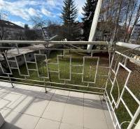 The balcony of a 2-room apartment on Ľ. Štúra in Zvolen with a view of the garden and trees.
