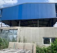 Warehouses and halls in Čaňa with a blue roof structure and concrete wall.
