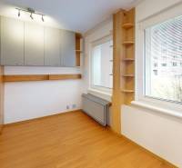 A room in a 3-room apartment with built-in wardrobes and a floor with a wood decor.