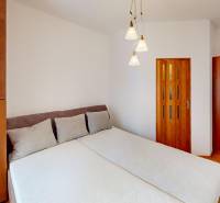 Bedroom in a 3-room apartment with a bed, wardrobe, and floor with a wooden decor.