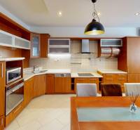 A kitchen in a 3-room apartment with a wood-patterned floor and built-in appliances.