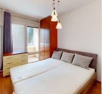 Bedroom in a 3-room apartment with a bed, wardrobe, and floor with wood decor.