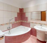A bathroom with a shower and a corner bathtub in a 3-room apartment.