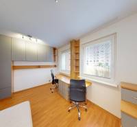 A work corner with a wooden decor floor in a 3-room apartment, large window, practical storage spaces.