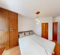 A bedroom in a 3-room apartment with a large built-in wardrobe and a floor with a wooden decor.