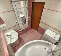 Bathroom in a 3-room apartment with tiles, a bathtub, and a washing machine.