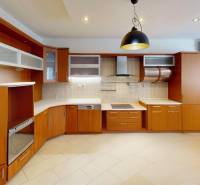 A kitchen with wooden decor and built-in appliances in a 3-room apartment.