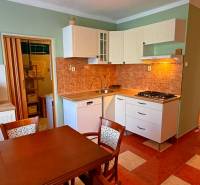 Kitchen in a 3-room apartment with a gas stove and a dining table.