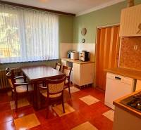 A kitchen in a 3-room apartment with seating area and appliances.