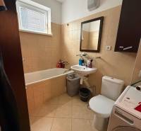 Bathroom with a bathtub, washing machine, and mirror in a 2-room apartment.