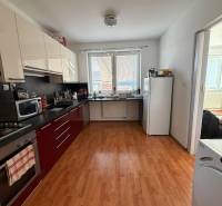 Kitchen in a 2-room apartment with a wooden decor floor and white walls.