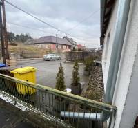 A family house on Osloboditeľov Street in Lieskovec, with garbage bins and a parked car.