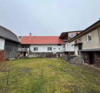 A family house on Osloboditeľov Street in Lieskovec with a grassy yard and farm buildings.