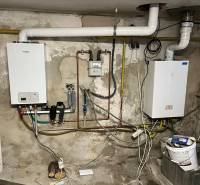 Gas boiler and pipes in the utility room of a family house.