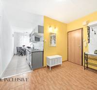 Entrance hall in a 3-room apartment with a wooden decor floor, leading to the kitchen and dining room.