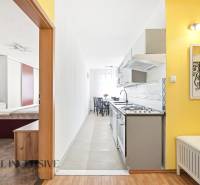 Interior of a 3-room apartment with wood-patterned flooring, kitchen, and bedroom.
