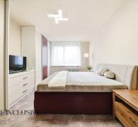 Bedroom in a 3-room apartment with a large bed, wardrobe, and floor with wooden decor.