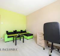 A stylish room in a 3-room apartment with a colorful sofa, table, and workspace.