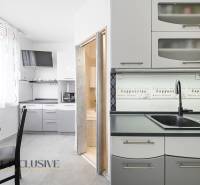 A kitchen in a 3-room apartment with a coffee decor and a dining area.