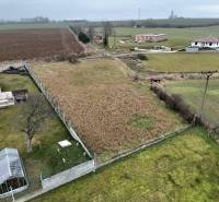 Plots - housing in Kuzmice on a quiet street with overgrown grass and a greenhouse.