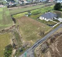 A residential plot in Kuzmice, a quiet street with a rural character and surrounding houses.