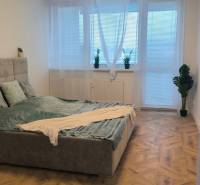 Bedroom with a gray bed, large window, and wood-patterned flooring in a 4-room apartment.