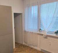 Kitchen in a 4-room apartment with a microwave, large windows, and a wooden decor floor.