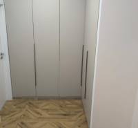 A hallway with a built-in wardrobe and a floor with a wooden decor in a 4-room apartment.