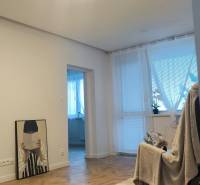 Living room in a 4-room apartment with a wooden decor floor and pendant lighting.