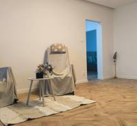 A bright living room with armchairs, a table, and a wooden decor floor in a 4-room apartment.