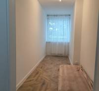 A narrow room with a window and a floor with a wooden decor in a 4-room apartment.