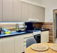 A kitchen in a 3-room apartment with a wooden decor floor and modern equipment.