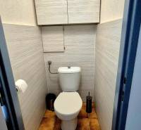 Bathroom with toilet in a 3-room apartment, tiles and practical storage cabinets.