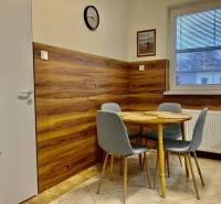 Kitchen with dining table, gray chairs, wooden decor flooring, 3-room apartment.